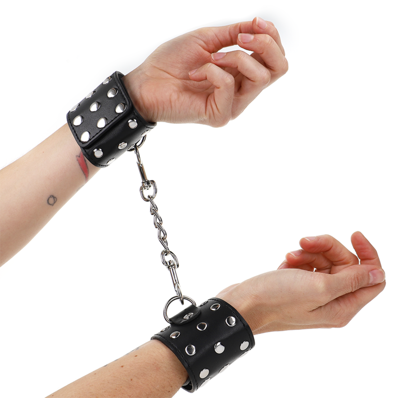 Imagen del artículo erótico KINK - MUÑEQUERAS CON CIERRE A PRESIÓN LLENO DE TACHUELAS AJUSTABLE NEGRO 19-24 CM X 5.5 CM de KINK WRIST RESTRAINT en la sección BDSM & BONDAGE |Bondage|Esposas de fijación de Millenial Sexshop.